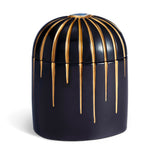 Dark blue cylinder candle posed from side to show gold drip details from eye motif
