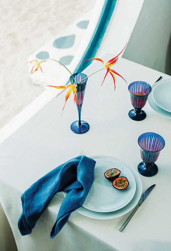 Summer Table with white porcelain plates and bright blue glassware