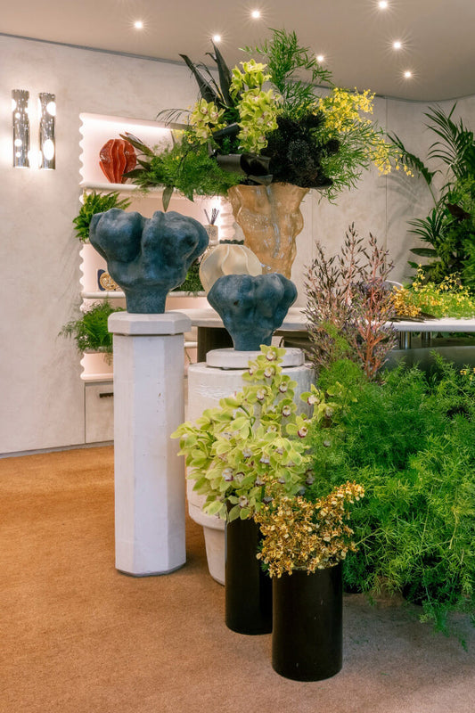Decorative display with potted plants and sculptures in a room setting.