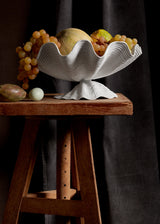 Neptune Bowl - Large. White porcelain shell-shaped bowl floating on a base. 